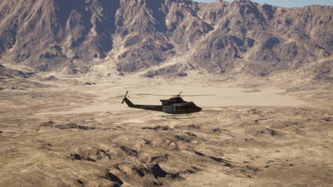 a helicopter flying over a desert landscape with mountains in the background