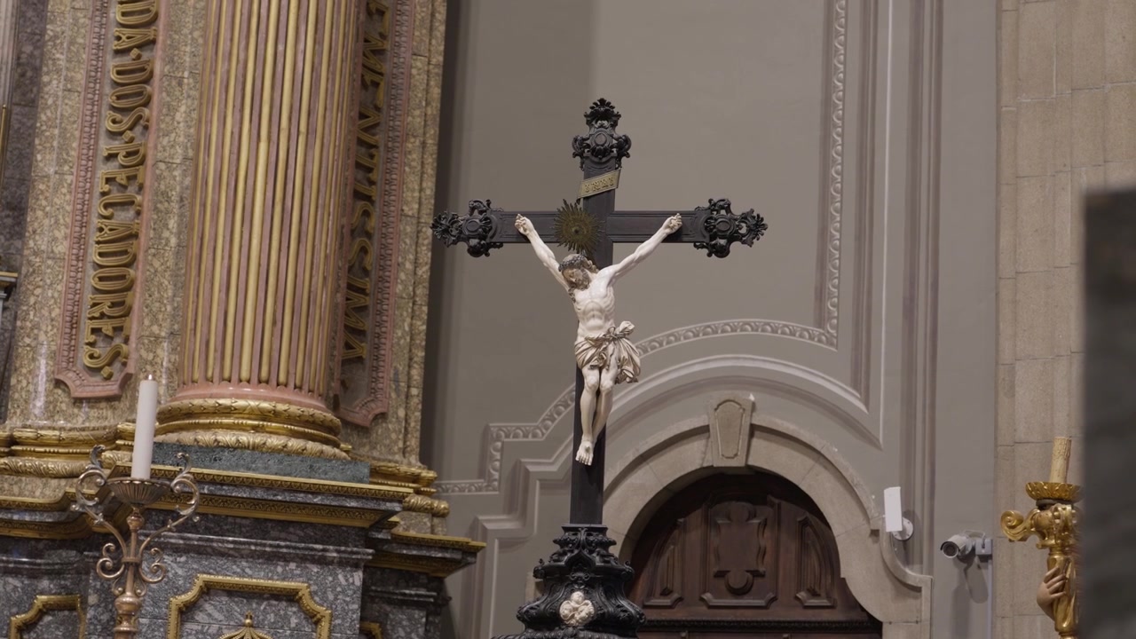 Carved Crucifix Standing Next To A Gilded Column And Altar Inside A Church In Portugal