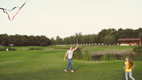 Feliz-Padre-E-Hija-Volando-Una-Cometa-Mientras-Corren-Juntos-En-El-Prado-En-Un-Parque-1