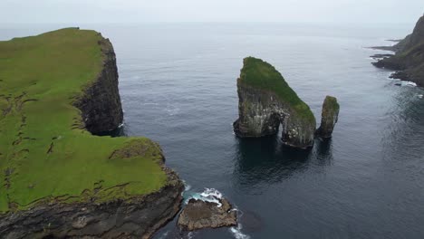 drangarnir sea stacks and oceanic archway covered in lush green grass