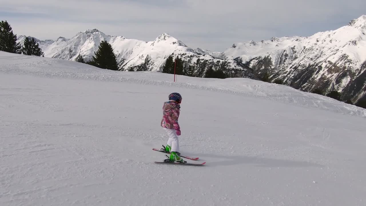 un niño pequeño está esquiando por una pista de esquí con la técnica de salvar el esquí