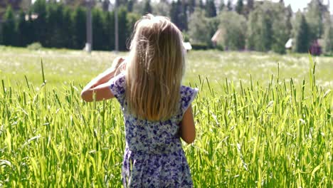 Blond-child-girl-on-meadow-in-summer-day