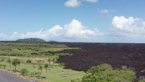 aerial rising wide shot of a recently dried lava flow cutting through the rainforest on the big island of hawaii