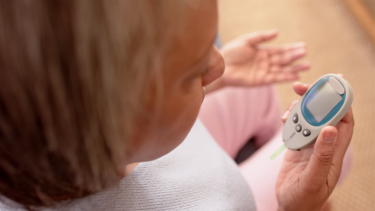 Donna anziana che controlla il livello di glucosio nel sangue con un glucometro, concentrandosi sulla salute.