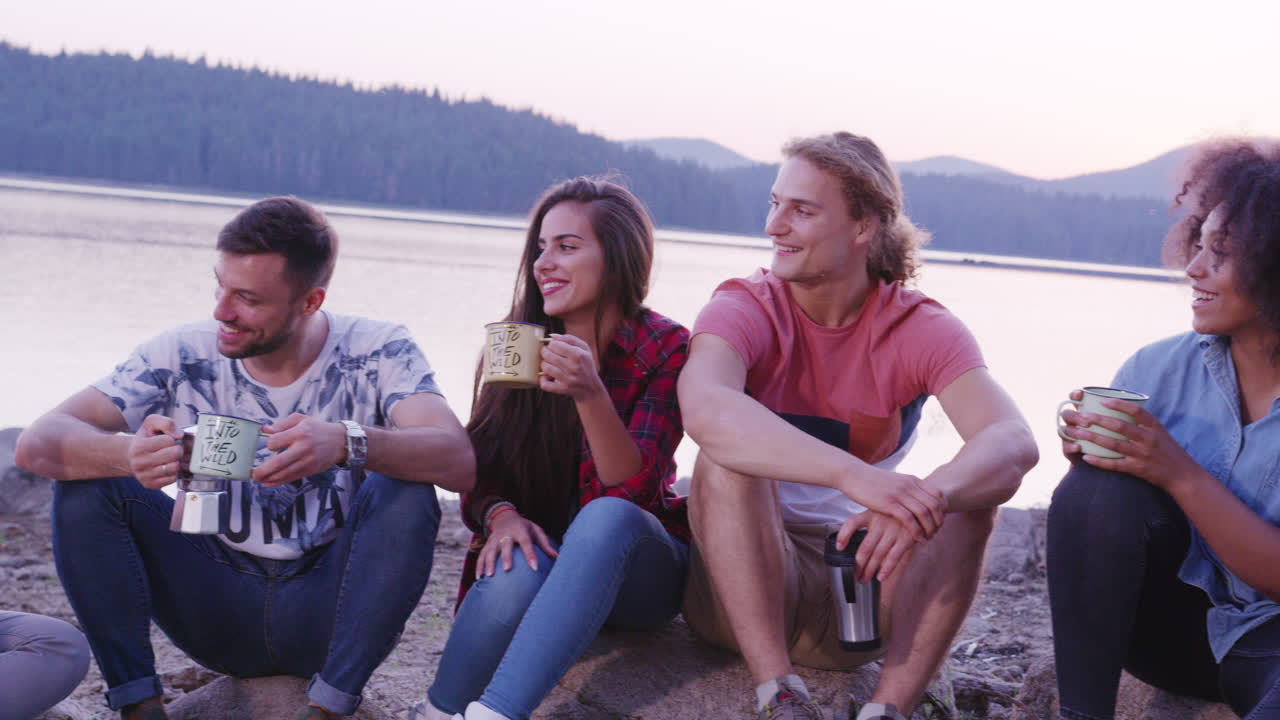 amigos disfrutando de acampar junto al lago