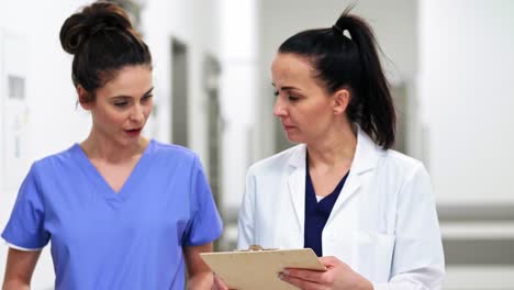 dos doctores mujeres ocupadas teniendo una conversación en el pasillo