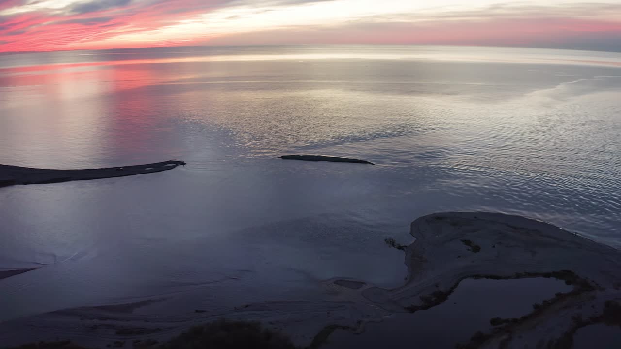 해안선의 흑해와 강 델타 위의 화려한 일몰 클라우드스케이프