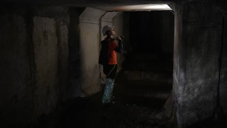 trabajador inspeccionando un túnel subterráneo o un alcantarillado