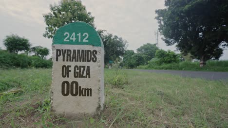 hito de la carretera que muestra la distancia de las pirámides de giza