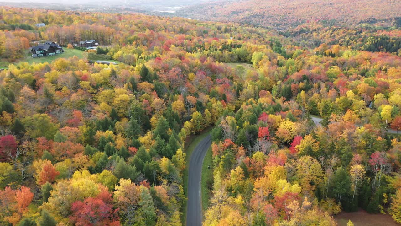 vista aérea, camino vacío, casas de campo y colorido bosque llamativo, vermont usa en 2020 durante la pandemia del virus covid-19, disparo de drones