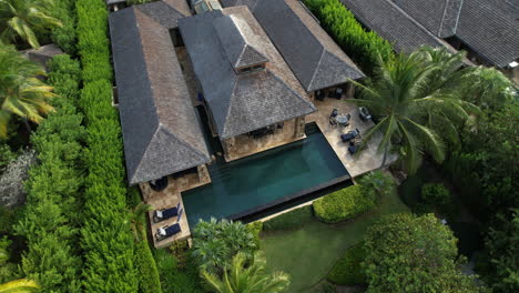 aerial view of luxury villa with private swimming pool in green tropical lush of exotic island