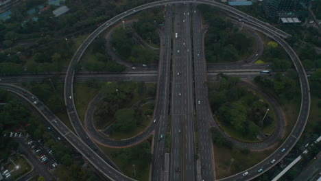 Aerial-dolly-tilt-shot-flying-over-busy-multi-lane-intersection-full-of-vehicles-in-modern-city-center