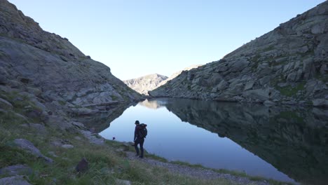 a-man-trekking-alone-in-the-mountains,-walking-away-from-the-camera