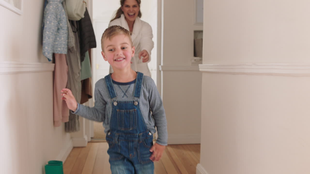 happy mother and son play catch running through house mom playing game chasing little boy enjoying fun weekend together 4k footage