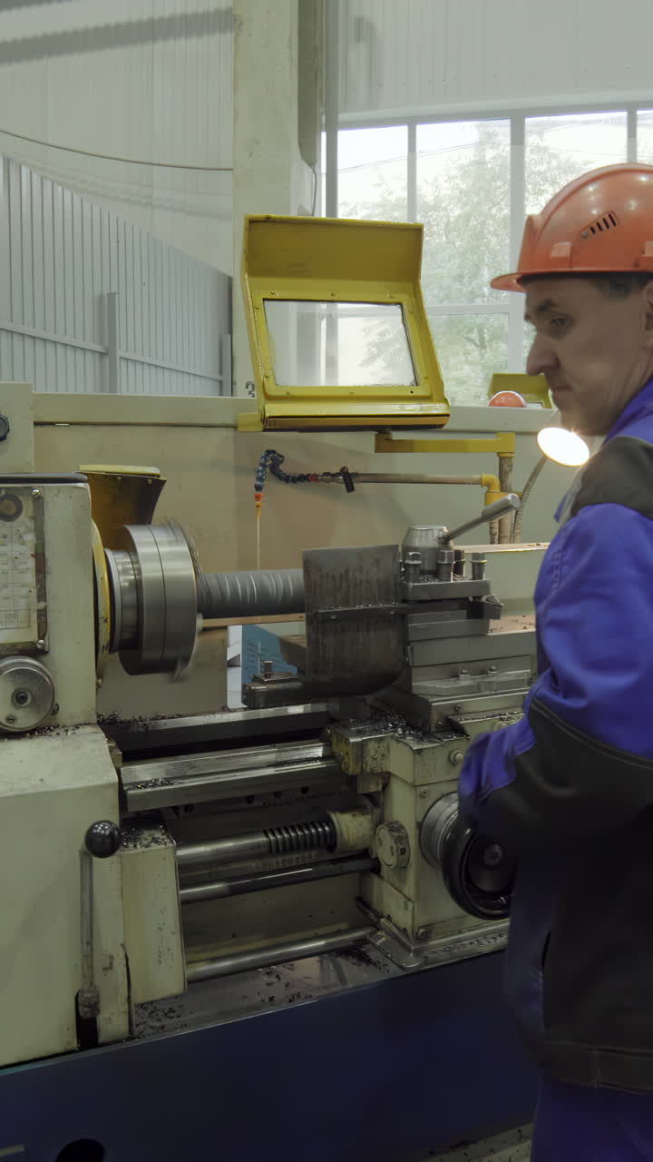 Worker Operating a Lathe Machine in an Industrial Workshop