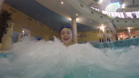 joyful kid enjoying hydromassage in the pool