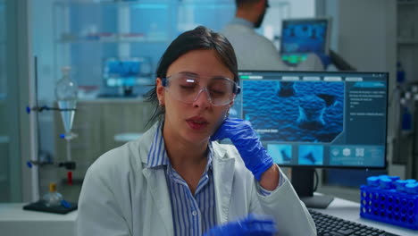 Outbreak-chemist-looking-tired-at-camera,-yawning-working-in-lab