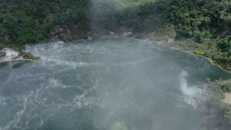 moviéndose más allá de los respiraderos de roca con vapor para revelar las aguas termales del lago sartén