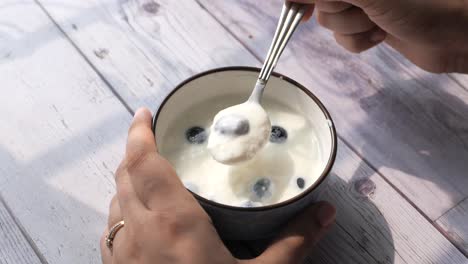 mujer comiendo yogur con arándanos