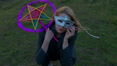 Slow-motion-shot-of-a-woman-crouched-wearing-a-mask-and-holding-a-lantern