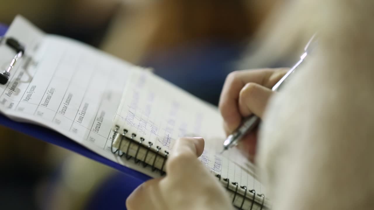 Human Hands Writing In Paper. Close-up of business human hands writing in paper