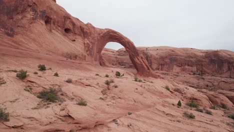 Drone-footage-of-corona-arch-in-moab-Utah-aerial-landscape-nature-red-rock-arch-formation-tourist