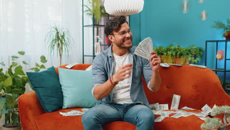 successful happy rich business man counting money cheering up with high profits lottery game win