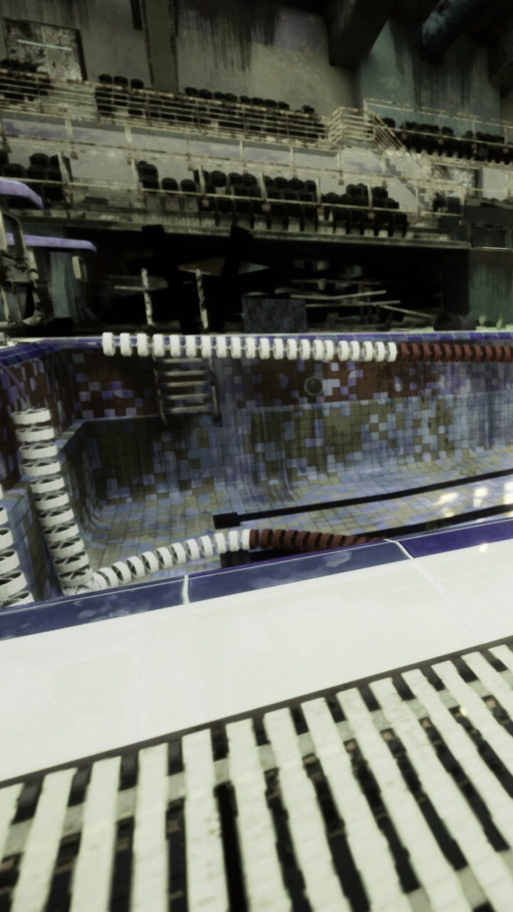 Empty swimming pool surrounded by worn bleachers and quiet atmosphere