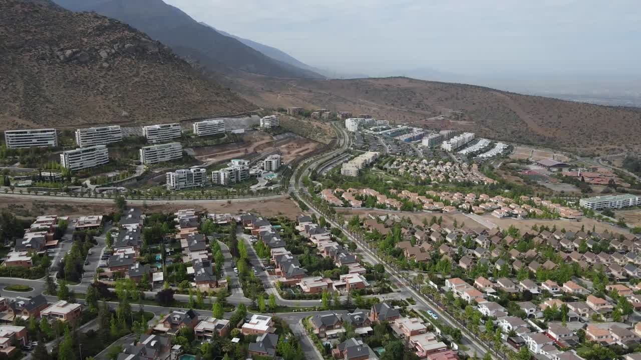 Tranquil residential area at the foot of the andes mountains, featuring houses, roads, and green spaces
