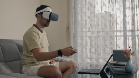 man interacts with vr headset while moving controller around in the air