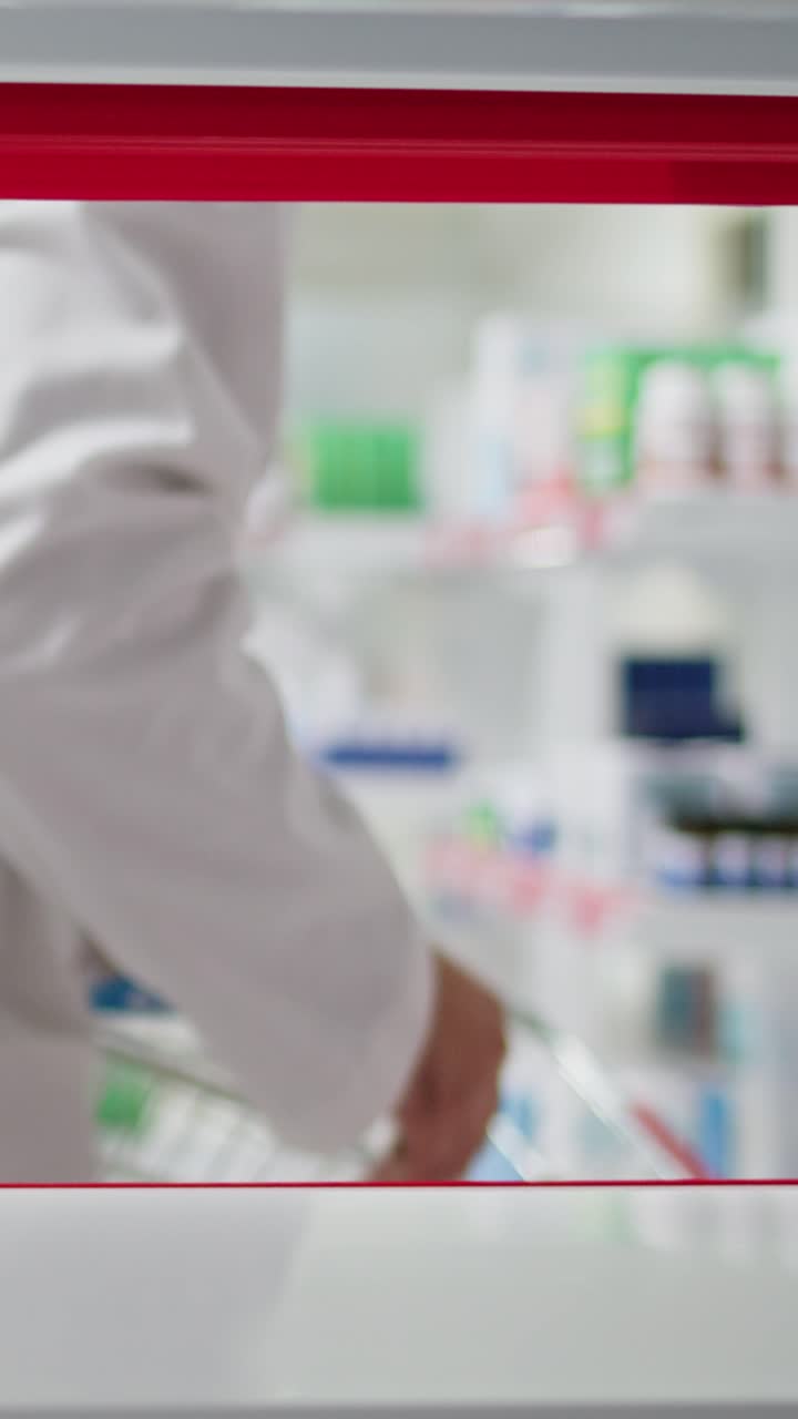 Vertikální video Farmaceutka vyklízí police pro reorganizaci zásob