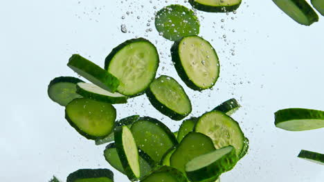 Rodajas-De-Pepino-Verde-Flotando-En-El-Agua-De-Cerca.-Verdura-Levantándose-En-Líquido