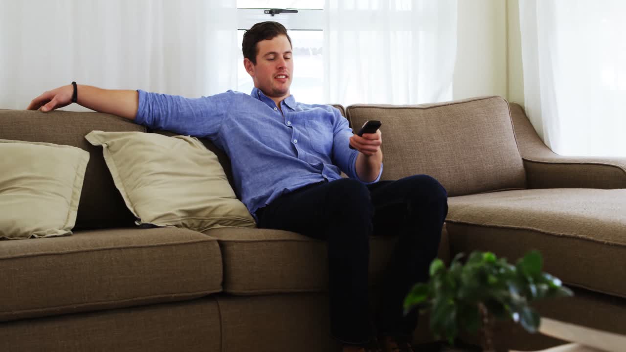 hombre discapacitado viendo televisión en el sofá 4k