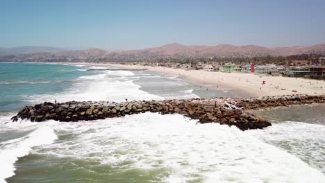 Antena-De-Un-Hombre-Pescando-En-Un-Rompeolas-Durante-Un-Gran-Oleaje-Con-Grandes-Olas-Frente-Al-Puerto-De-Ventura,-California-6