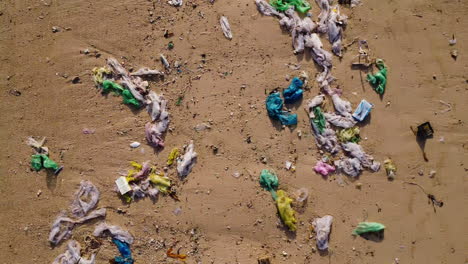 aerial birds eye flyover dirt and waste polluting sandy beach in vietnam