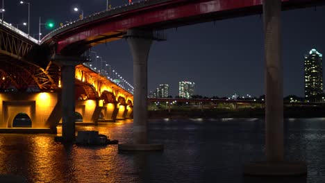 han river flowing under seongsu bridge at night in seoul, south korea