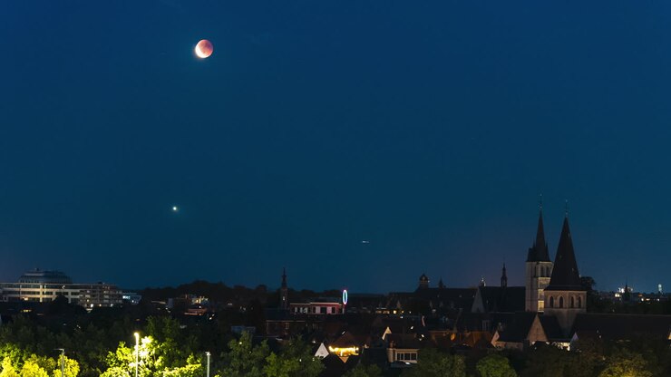 Luna rossa che sorge sopra il paesaggio urbano di Mechelen, vista time-lapse
