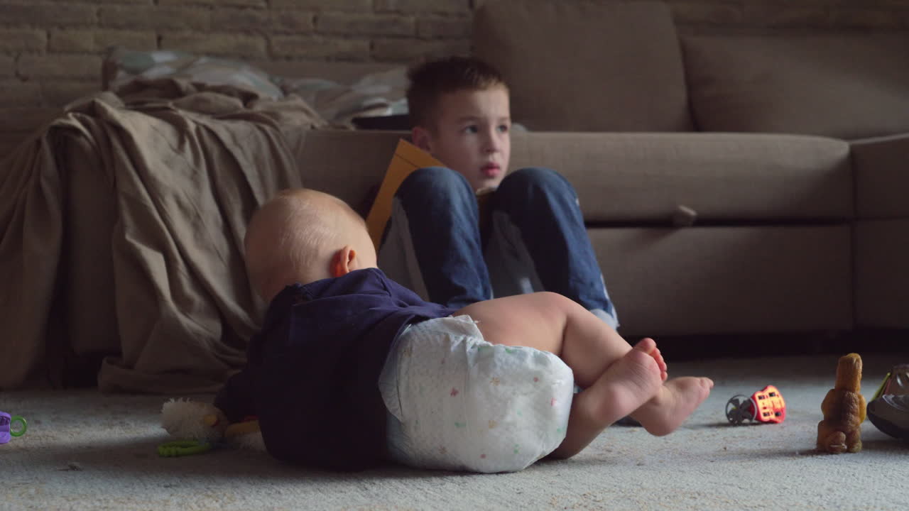 Bambino che gattona vicino al fratello