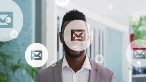 animation of envelope icon in circles over smiling african american man standing in office