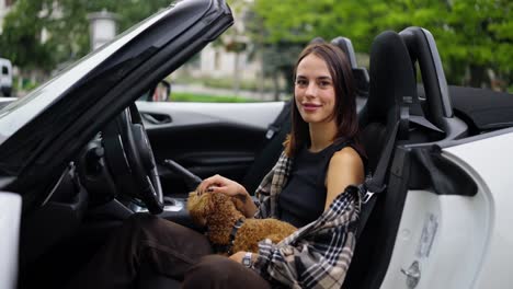mujer con perro en coche descapotable