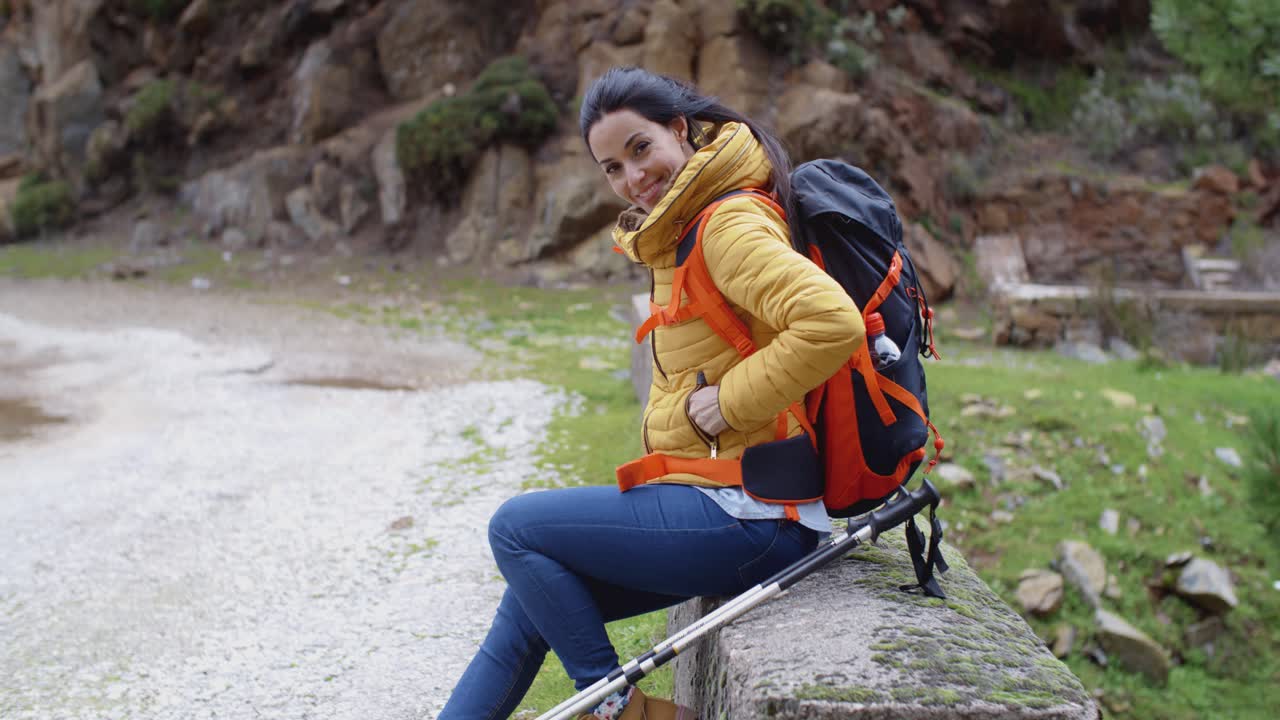 una joven sonriente en un sendero de montaña