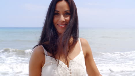 Una-Mujer-Joven-Y-Bonita-En-La-Playa-Sonriendo-A-La-Cámara