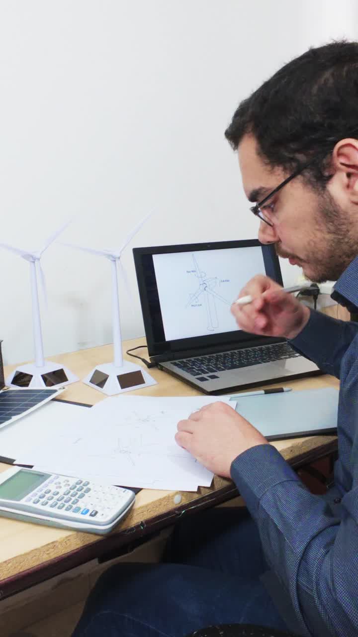 Engineer Drawing a Blueprint at His Desk, Side View