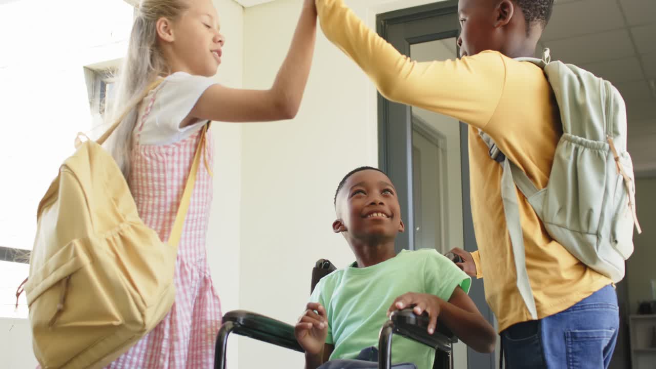 Diverse teens high-fiving over wheelchair, girl offering book, showing inclusion at school door