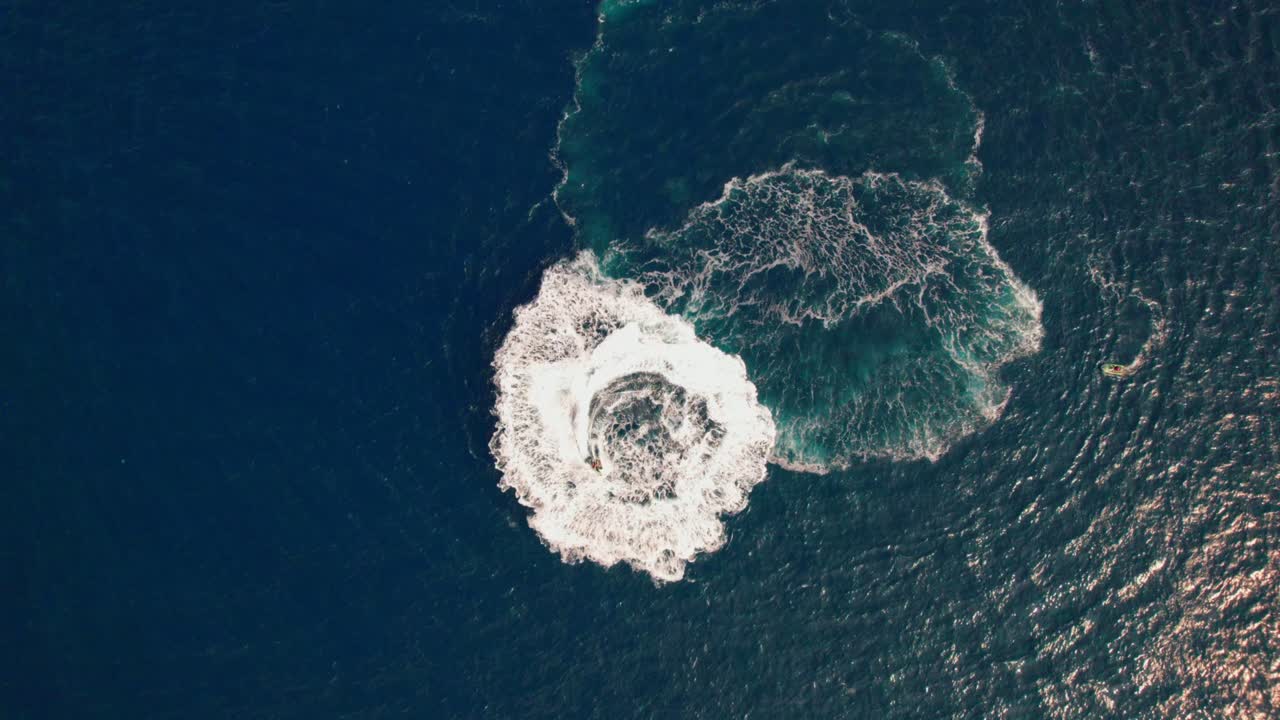 Drone over cirkulerende jetski ud for kysten ved Cap de Creus