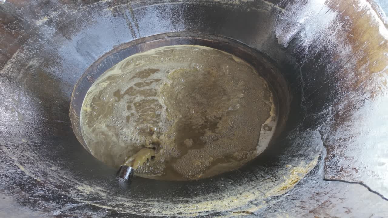 Process of Making Jaggery: Sugarcane Syrup Bubbling in a Rustic Pot