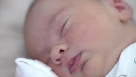 adorable babe sleeping peacefully with its hand under the chick. rosy cheeks, tiny nose and lips close up.