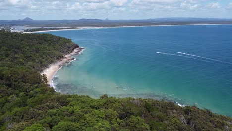 flying over forest and coastline and the ocean in the background