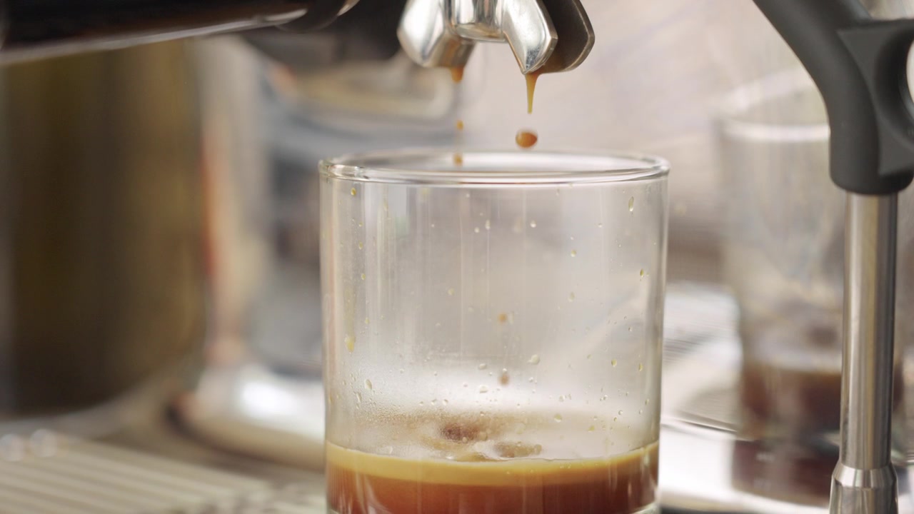 Ultime gocce di caffè espresso schizzano nel bicchiere.