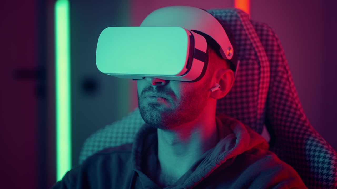 cyber gamer con occhiali vr gioca a giochi di realtà virtuale nello spazio futuristico al neon. concetto di gioco. giovane uomo bello si guarda intorno e spara con una pistola blaster virtuale. filmati 4k di alta qualità